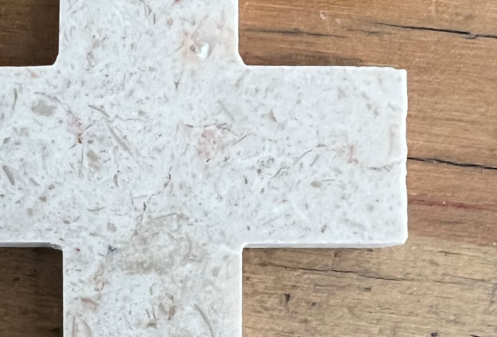 Closeup of Jerusalem stone cross on wooden table