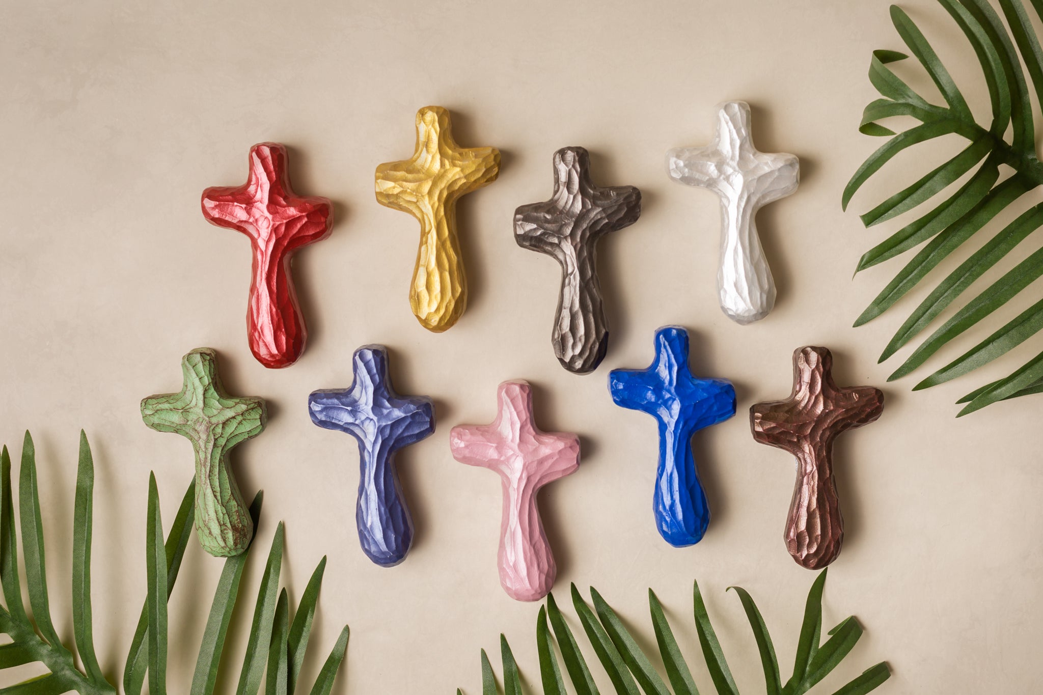 Nine painted wooden crosses with palm leaves